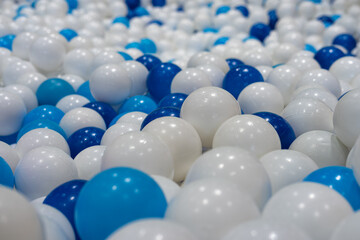 Blue and white plastic balls in ball pit at kids playground. Colorful plastic ball texture background. 