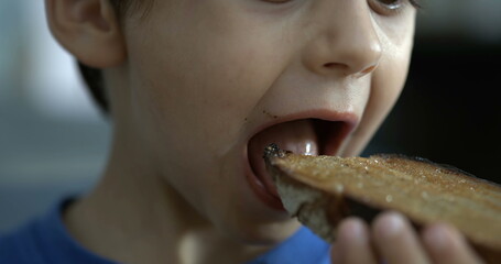 Little boy eating toast bread, close-up child mouth takes a bite of food in speed ramp