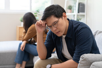 Family problem concept, Asian wife and husband sitting back to back in the living room at home have...