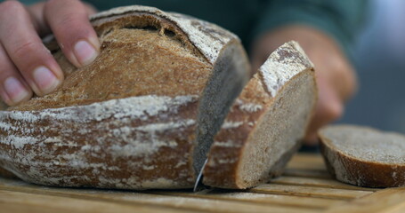 Slicing piece of bread in , close-up carb food cutting