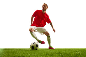 Professional soccer player looks confident in sportwear and boots training kicking ball for goal in jump against white background. Football school.
