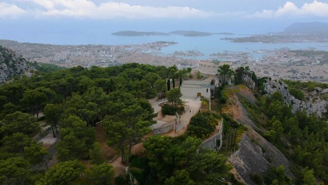 Aerial video of M&eacute;morial du D&eacute;barquement et de la Lib&eacute;ration en Provence. Footage was shot from a drone from above the trees, with Toulon city and the Mediteranean bay in the background.