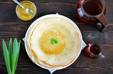 round thin pancakes with maple syrup on the table flat lay