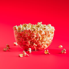 Glass Bowl Filled with Freshly Popped Popcorn on Vibrant Red Background