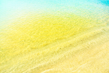 Calm waves on an empty sandy beach. Romantic background on the theme of vacation and a pleasant, relaxing holiday.