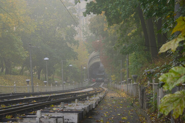 Foggy autumn landscape view of funicular cabin in the lower station. All passengers inside and waiting for departure to the upper station. Funicular is popular transport among locals and tourists