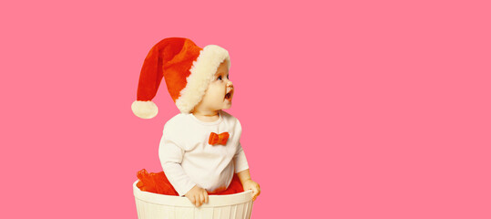 Happy smiling little child in christmas santa red hat playing with toys looking away on blank copy...