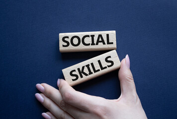 Social skills symbol. Wooden blocks with words Social skills Beautiful deep blue background. Businessman hand. Business and Social skills concept. Copy space.