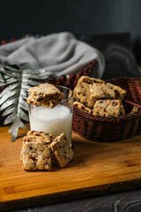 Crunchy cookies biscuits served in plate with glass of milk isolated on table side view of american cafe baked food