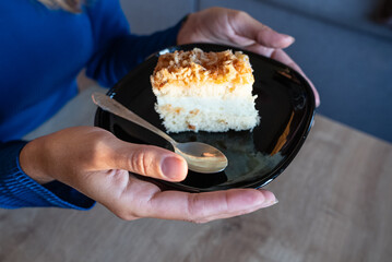 The woman holds food in her hand. the girl holds in her hands. Cake on plate.