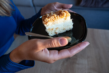 The woman holds food in her hand. the girl holds in her hands. Cake on plate.
