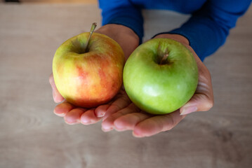 The woman holds fruits in her hand. The girl holds an apple. Apples in woman's hands. Green apples.