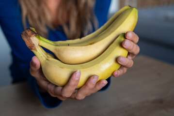 The woman holds food in her hand. the girl holds in her hands