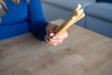 The woman holds food in her hand. Girl holds Grissini in her hands. Italian grissini holding by women.