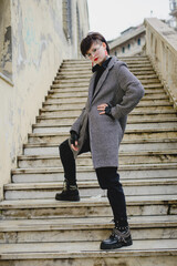 Young girl in coat with short black hair posing on stairs. Lifestyle. Outdoor autumn