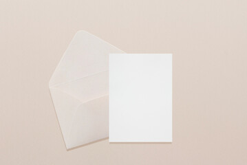 Wedding stationery invitation card mockup 5x7 and beige envelope on neutral beige background, bridal shower mockup. Minimal blank card mockup, thank you card, greeting card