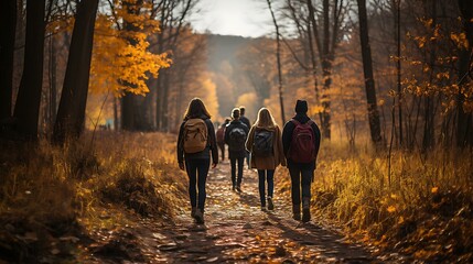Uma imagem pitoresca de uma família ou grupo de amigos fazendo trilha por uma floresta com folhagem vibrante de outono no Dia de Ação de Graças. - obrazy, fototapety, plakaty