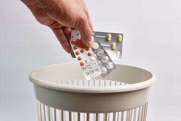 Expired pills are thrown into the trash for recycling or disposal.