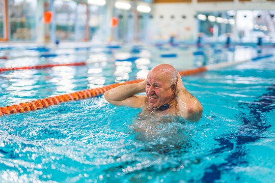 old cheerful man having fun in the pool, well-being concept. High quality photo