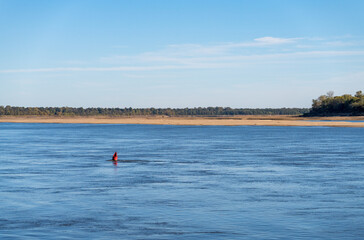 Extreme low water conditions on Mississippi river in October 2023 with red buoy marking river channel in Missouri
