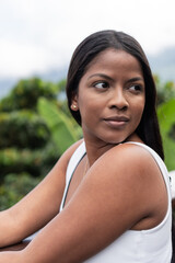 ortrait of a woman looking to the side while standing outdoors.