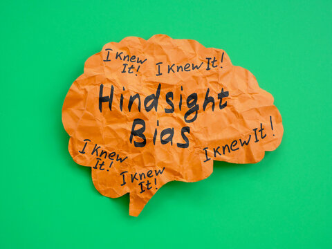Brain made of paper with inscription Hindsight bias.