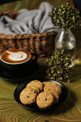Crunchy cookies biscuits served in plate with coffee latte art isolated on table side view of american cafe baked food