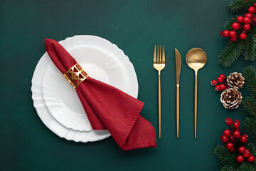 Clean plate, gold cutlery. Festive table setting with christmas decorations. Celebration xmas eve:...