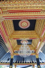 The ceiling of a traditional Javanese building is full of gold-painted carved ornaments, at Sultan palace of Yogyakarta