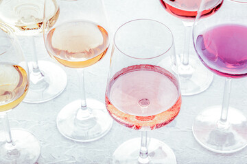 Wine glasses at a tasting. Rose, red, and white wine, drinks on a table at a winery, toned image. An assortment of wines of many different colours - Powered by Adobe