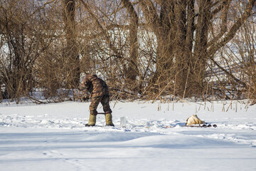 Back view of a fisherman on the ice during ice fishing