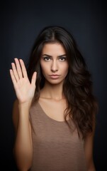 Young beautiful caucasian woman doing stop gesture with palm of the hand. Warning expression with negative and serious gesture on the face dark background.