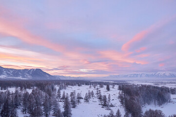 Cold snowy mountain landscape at sunset. Panoramic view of snowy mountain peaks and slopes of North Chuyskiy ridge at sunset. Russia, Siberia, Altai mountains.