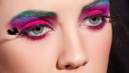 Crop of female eye with colorful make up. Beautiful fashion model with creative art makeup.