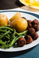Green beans, potatoes and meatballs on a plate