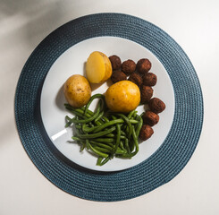 Green beans, potatoes and meatballs on a plate