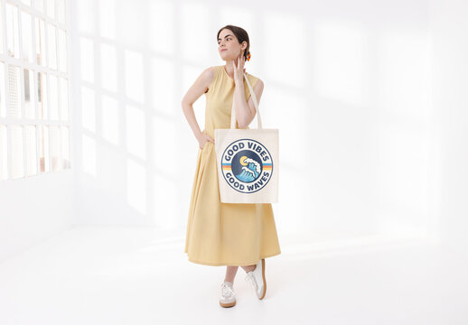 Mockup of young woman with customizable tote bag, looking away