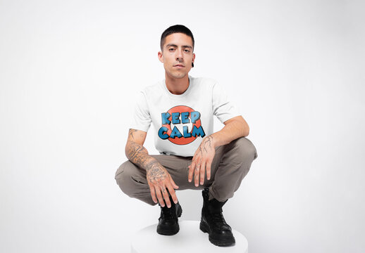 Mockup of young man wearing customizable t-shirt crouching down