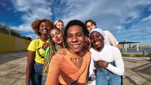 young gay man taking selfie with group of gen Z and Millenial generation friends