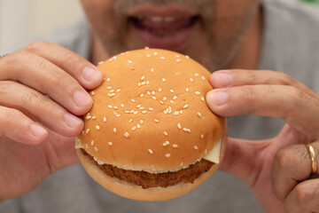 Close-up of man eating hamburger with eyes closed