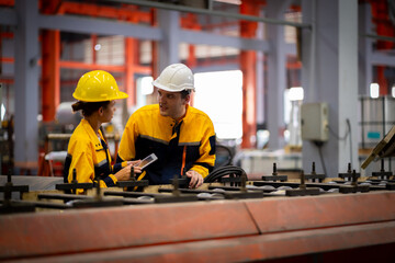 Team of young male and female engineers in a metal sheet factory Responsible work is being inspected at the actual work site.