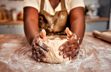 Details in baking process. Close up of black female hands molding raw dough on wooden table...