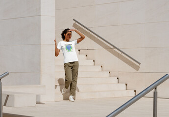 Mockup of woman wearing customizable t-shirt by steps outdoors