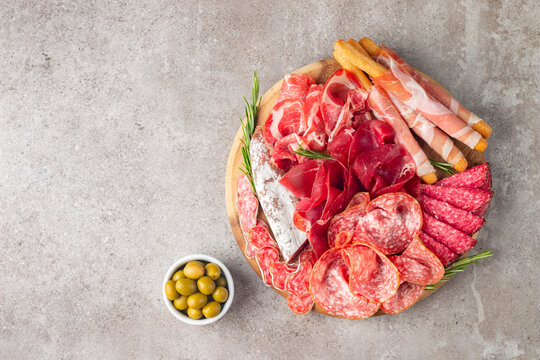 Charcuterie board. Antipasti appetizers of meat platter with salami, prosciutto crudo or jamon and olives