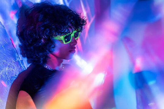 Contemplative latin man with neon shades among lights