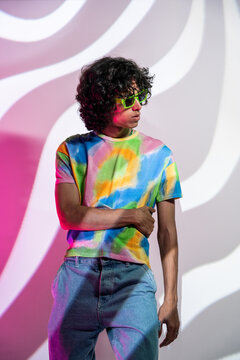Stylish latin man in tie-dye against geometric background