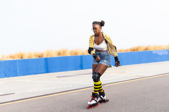 Woman Rollerskating On Rink At Skate Park Against Cloudless Sky