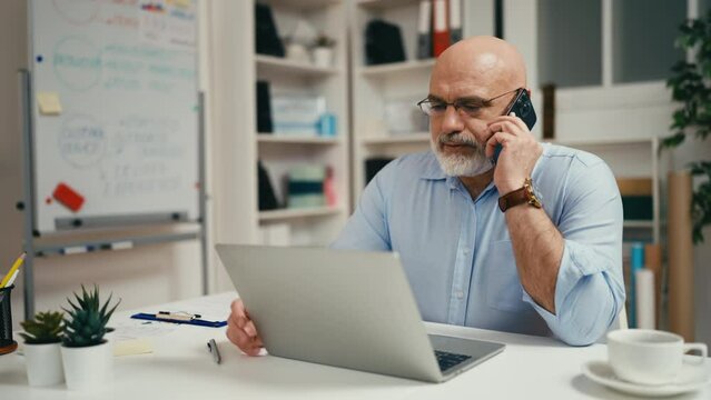 Confident man in his 40s talking on phone, businessman in office, entrepreneur