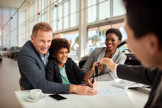 Happy family finalizing a car purchase at a dealership