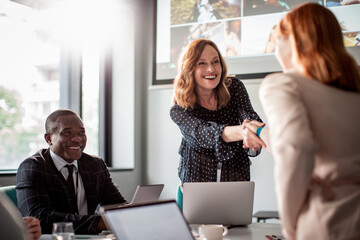 Colleagues share a joyful moment during a conference room presentation
